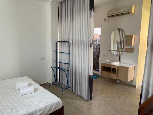 a small room with a bed and a desk at Atrium Cottage in Seeduwa