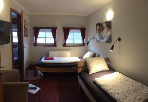 a small room with two beds and a couch at Penzion Slunečnice in Rokytnice nad Jizerou