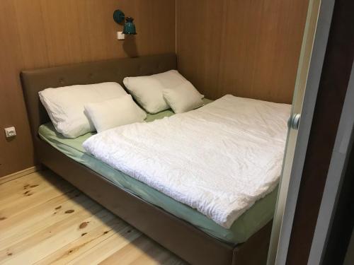 een bed in een kleine kamer met twee kussens erop bij TIRAMISU Vendégház in Csókakő