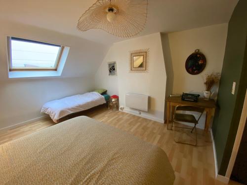 une chambre avec un lit, une table et une fenêtre dans l'établissement Gîte À bon port Abbeville 5 personnes, à Abbeville