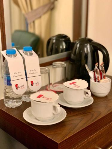 a table with two cups and a bottle of water at Ream Hotel Amman in Amman
