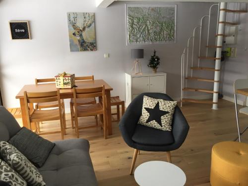 un salon avec un canapé et une salle à manger dans l'établissement Gîte chaleureux au lac de Payolle, à Campan