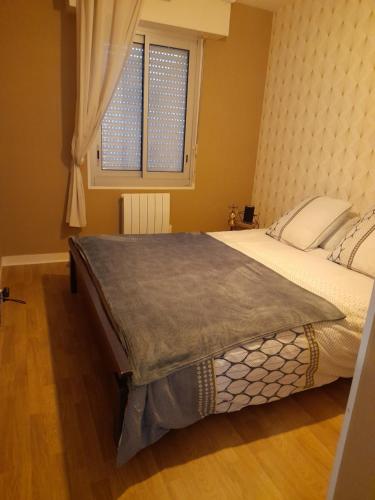 a bedroom with a large bed with a window at Superbe appartement in Saint-Quay-Portrieux