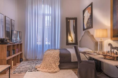 a bedroom with a bed and a desk and a mirror at Arnaboldi Palace in Pavia