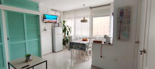 cocina con nevera y mesa en una habitación en J&H Apartment en Torremolinos
