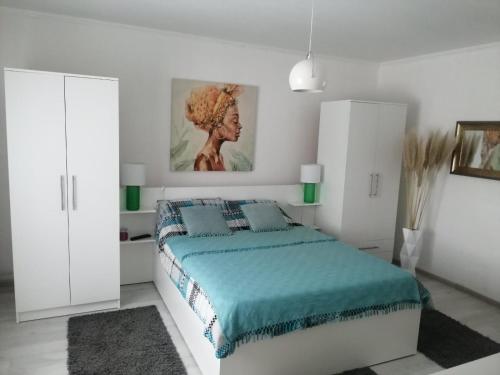 Un dormitorio blanco con una cama y un cuadro en la pared. en ZOĆEVIĆA KONAK, en Petrovići