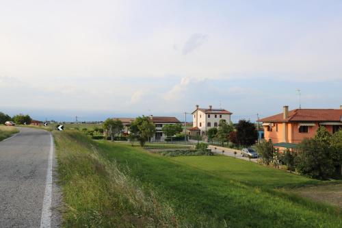 a road in a village with houses in the distance at Casa al Piave - appartamento a 5 km dal mare in Eraclea