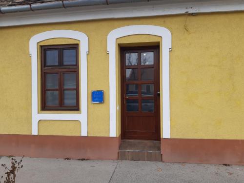 a yellow building with two doors on it at Ady Apartman in Tata