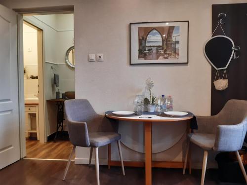 Habitación con mesa con sillas y espejo. en Ady Apartman, en Tata