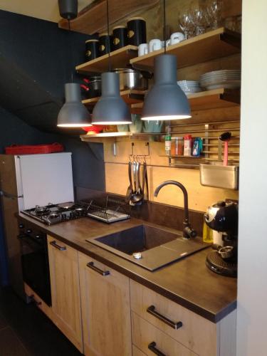 a kitchen with a sink and a stove and pendant lights at LES CHALET Kranjska Gora I in Kranjska Gora
