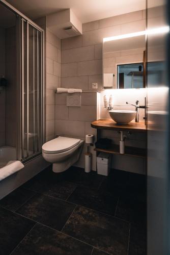 a bathroom with a toilet and a sink at CHRIStania in Fiesch