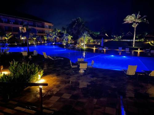 Eco Resort Praia dos Carneiros ao lado da Igrejinha ! في تامانداري: حمام سباحة كبير في الليل مع أضواء
