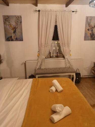 a bedroom with two beds with towels on a table at The Little Blue House in Reşiţa