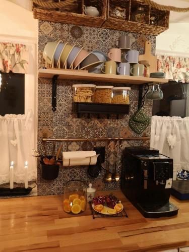 a kitchen with a microwave and a table with food at The Little Blue House in Reşiţa