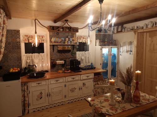 a kitchen with white cabinets and a table in a room at The Little Blue House in Reşiţa