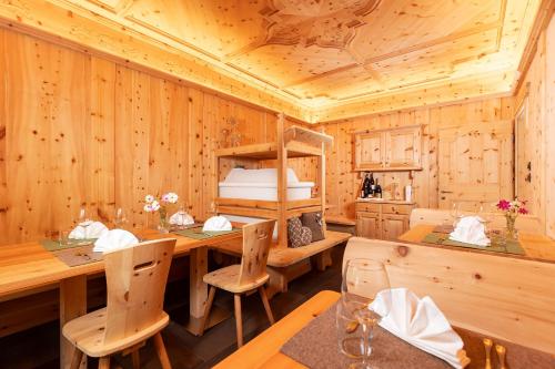 a wooden dining room with a table and chairs at Alpenhotel La Montanara in Rocca Pietore
