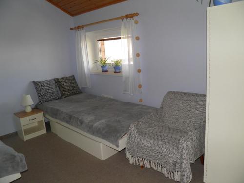 a bedroom with a bed and a chair and a window at Privat Kovacova in Žiar