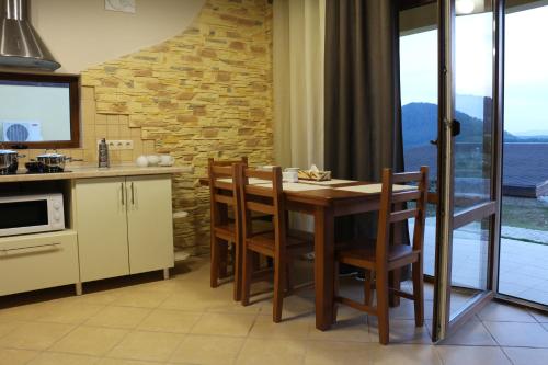 a kitchen with a wooden table and chairs in a kitchen at West Wood ApartHotel in Knyagynya