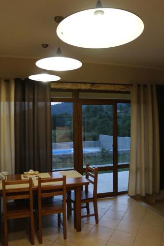 a dining room with a table and a large window at West Wood ApartHotel in Knyagynya