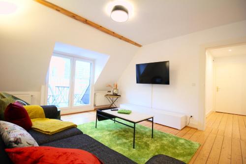 ein Wohnzimmer mit einem Sofa und einem Tisch in der Unterkunft JUNIK Apartments Oberhausen in Oberhausen