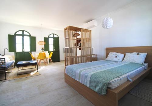 a bedroom with a bed and a living room at Casa Frajo in Fuzeta