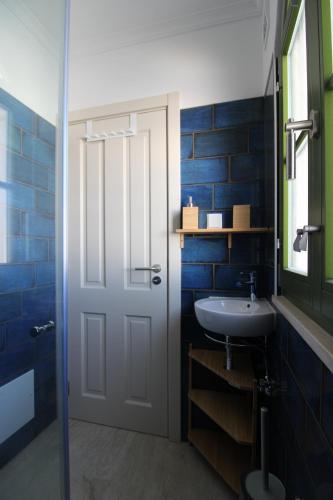a bathroom with a white door and a sink at Casa Frajo in Fuzeta