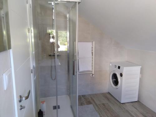 uma casa de banho com um chuveiro e uma máquina de lavar roupa em Apartamento Ría de Vigo em Pontevedra