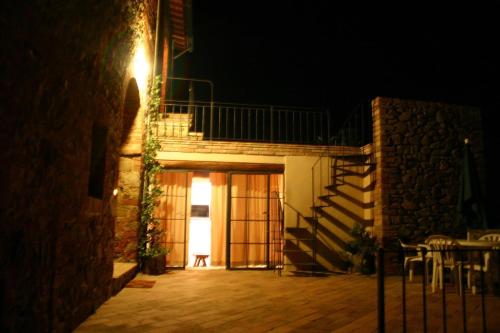 a building with a staircase leading to a patio at night at Podere Campovecchio in Rapale