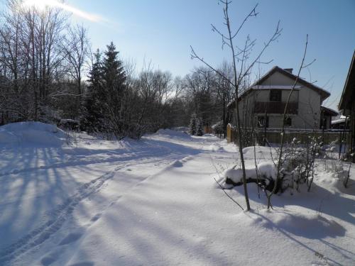 a snow covered road in front of a house at Privat Kovacova in Žiar