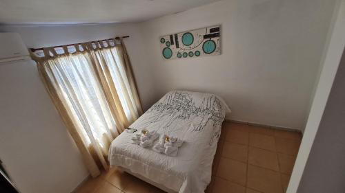 a bedroom with a bed with two stuffed animals on it at Vicky House in La Falda