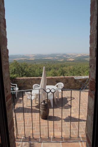 a balcony with chairs and a table with a view at Podere Campovecchio in Rapale