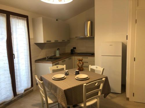 uma cozinha com uma mesa com cadeiras e um frigorífico branco em Casa Fiorita em Negrar