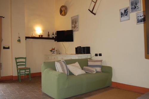 a living room with a green couch with pillows at Podere Campovecchio in Rapale