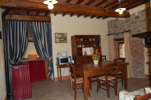 a living room with a wooden table and a microwave at Podere Campovecchio in Rapale