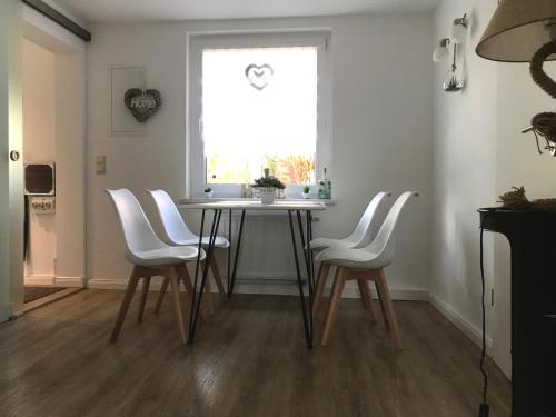 巴德施米德貝格的住宿－Pension an den Weinbergen，一间带桌子和白色椅子的用餐室