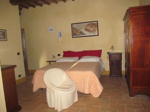 a bedroom with a large bed with a white ottoman at Podere Campovecchio in Rapale