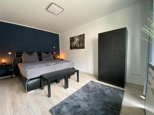 1 dormitorio con cama y pared negra en Haus am Brunnen Wohnung 2, en Klosterkumbd