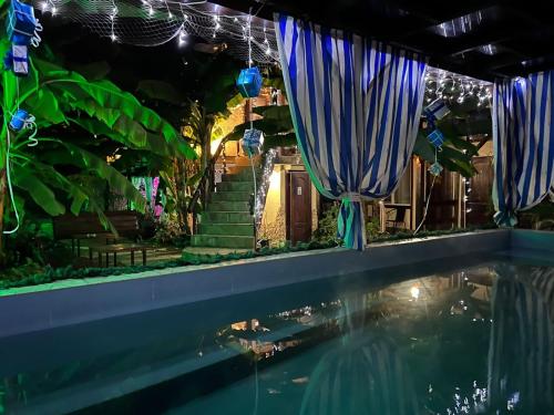 a pool with blue umbrellas next to a house at U Palycha Guest House in Sukhum