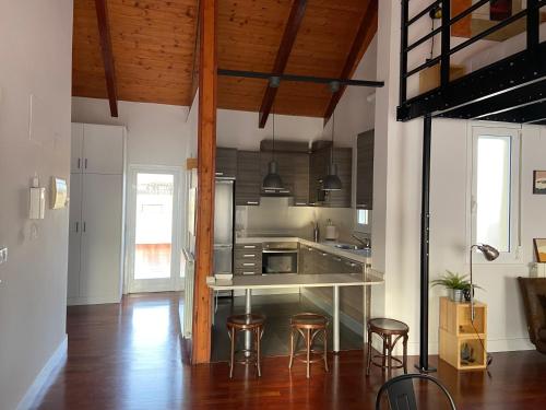 a kitchen with a counter and some stools in it at Rooftop Alfonso in Zaragoza