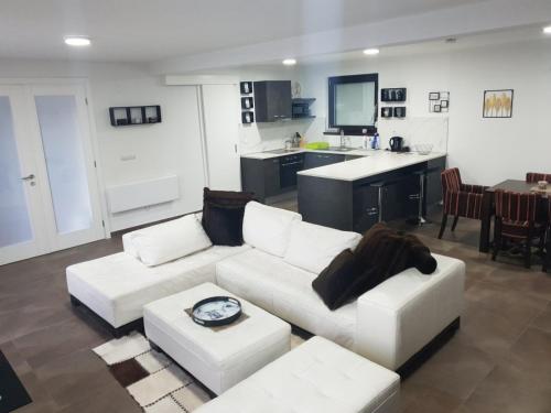 Villa Arkado في سراييفو: غرفة معيشة مع أريكة بيضاء ومطبخ