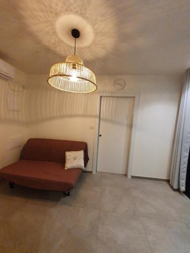 a living room with a couch and a chandelier at קשת לכנרת-יחידת הקרקע in Keshet