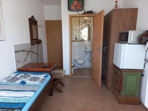 Habitación pequeña con cama y nevera. en Pokoje goscinne DW Antom en Dźwirzyno
