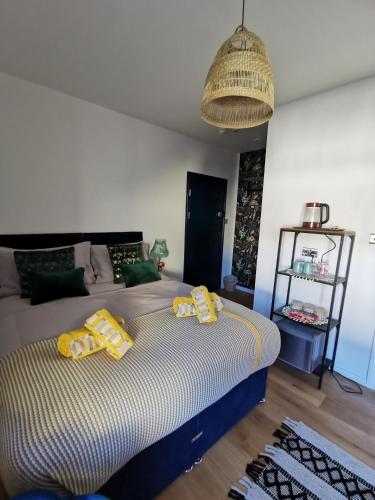 a bedroom with a bed with yellow pillows on it at Flamingo Lodge in Torquay