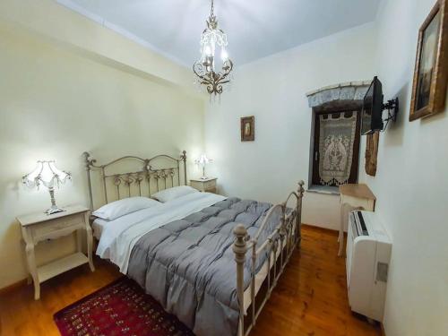 um quarto com uma cama grande e um lustre em Archontiko-Vytina em Vytina