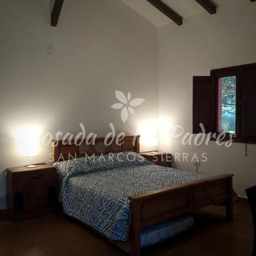 a bedroom with a bed and a sign on the wall at Posada de los Padres - LOS OLIVOS in San Marcos Sierras
