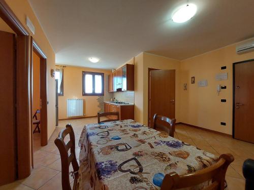 a dining room with a table and a kitchen at Agriturismo Il Melograno in Tessera