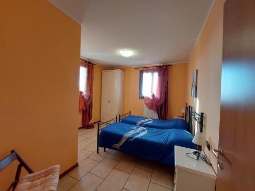 a bedroom with a bed and a desk and window at Agriturismo Il Melograno in Tessera