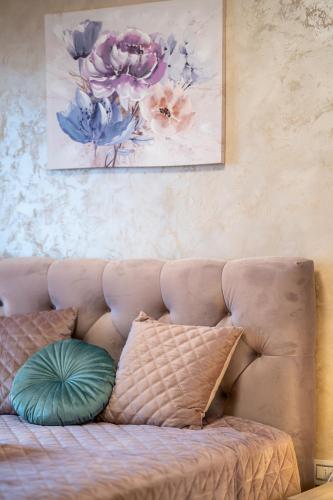 a couch with pillows and a painting on the wall at Apartman Lux M&B in Zlatibor