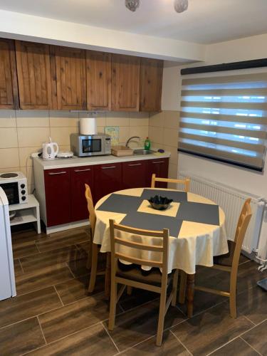 a kitchen with a table and chairs in a room at NG Apartmani Tornik Zlatibor in Zlatibor