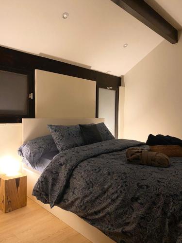 ブレモンにあるCOCOONING near DINANT 300m from River Meuseのベッドルーム1室(黒いヘッドボードと枕付きのベッド1台付)
